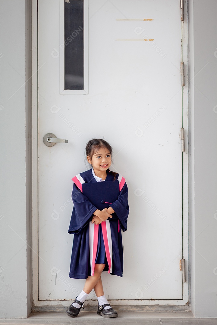 Meninas asiáticas felizes em vestidos de formatura no dia da formatura na escola.