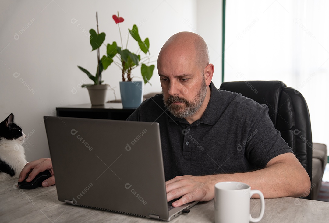 Homem de meia-idade brasileiro usando um laptop trabalhando em casa