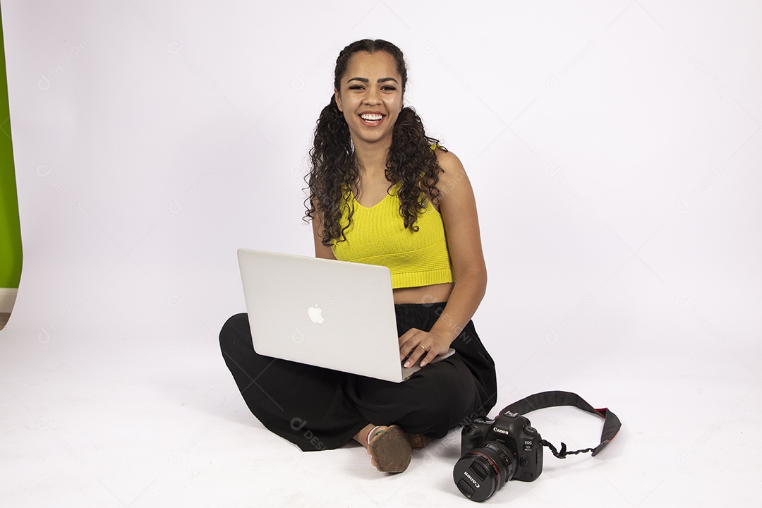 Linda mulher garota jovem segurando notebook e uma câmera fotográfica sobre fundo isolado