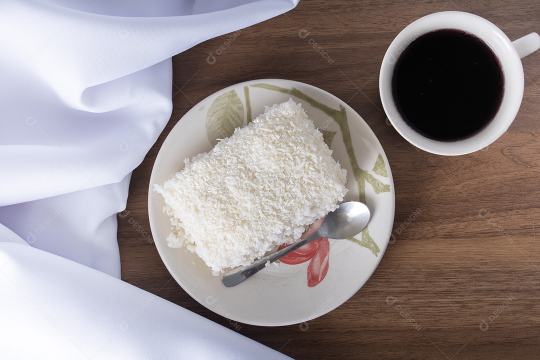 Pedaço de cuscuz em pires de porcelana sobre mesa de madeira