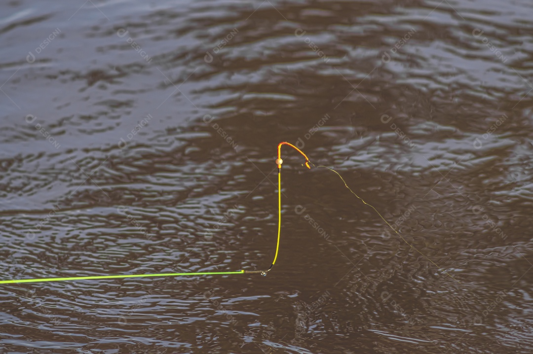 Conceito de pesca com bóia de pesca na água com linha, luz natural.