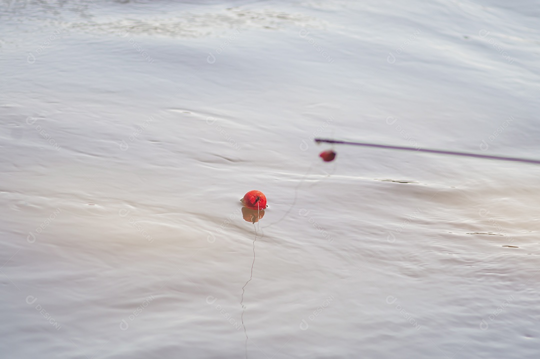Conceito de pesca com bóia de pesca na água com linha, luz natural.