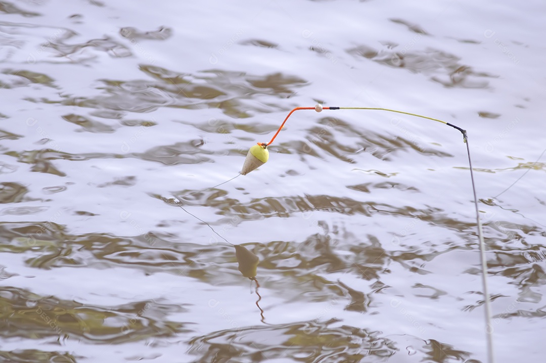 Conceito de pesca com bóia de pesca na água com linha, luz natural.