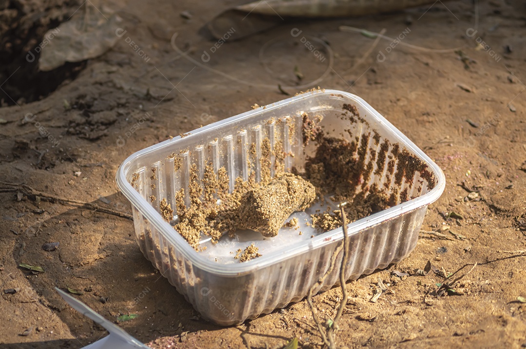 Tigela com sobras de massa de pesca deixadas no chão pelos pescadores.
