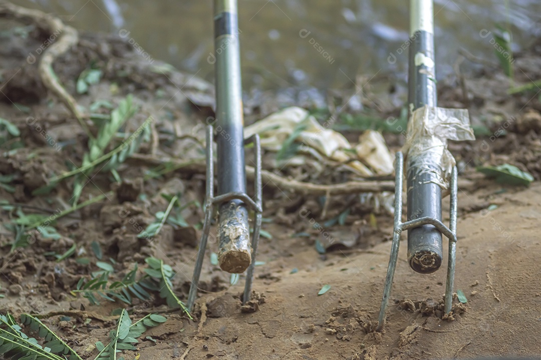 Varas de pesca presas no suporte à beira de um rio, conceito de pesca.
