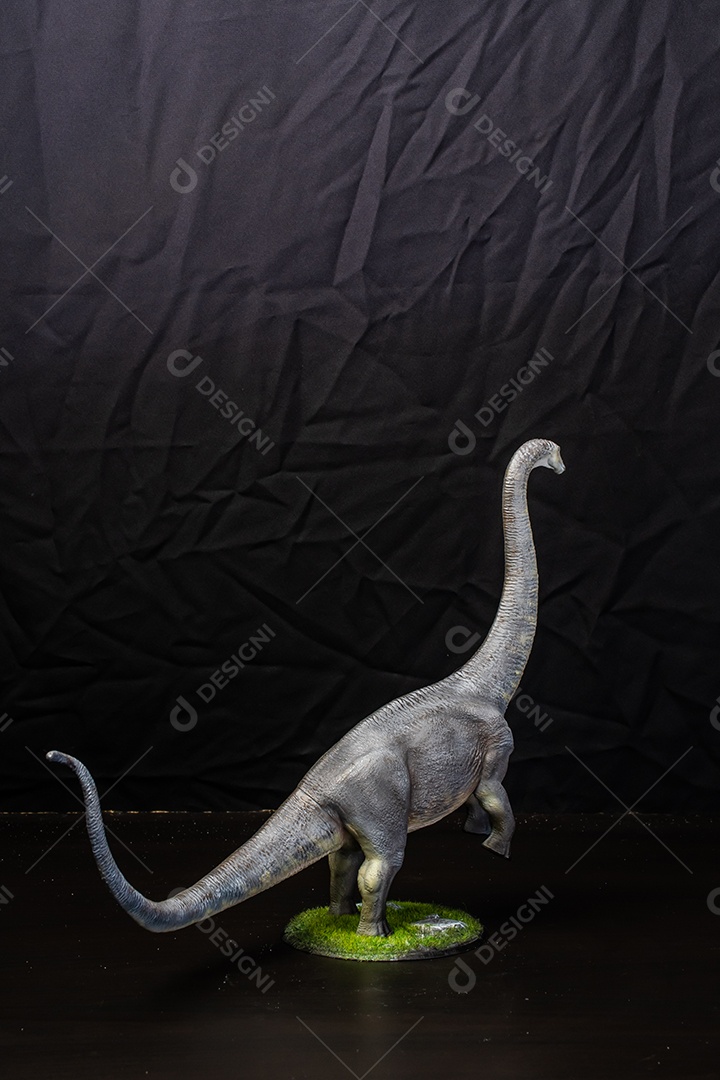 Belo dinossauro sobre fundo escuro isolado