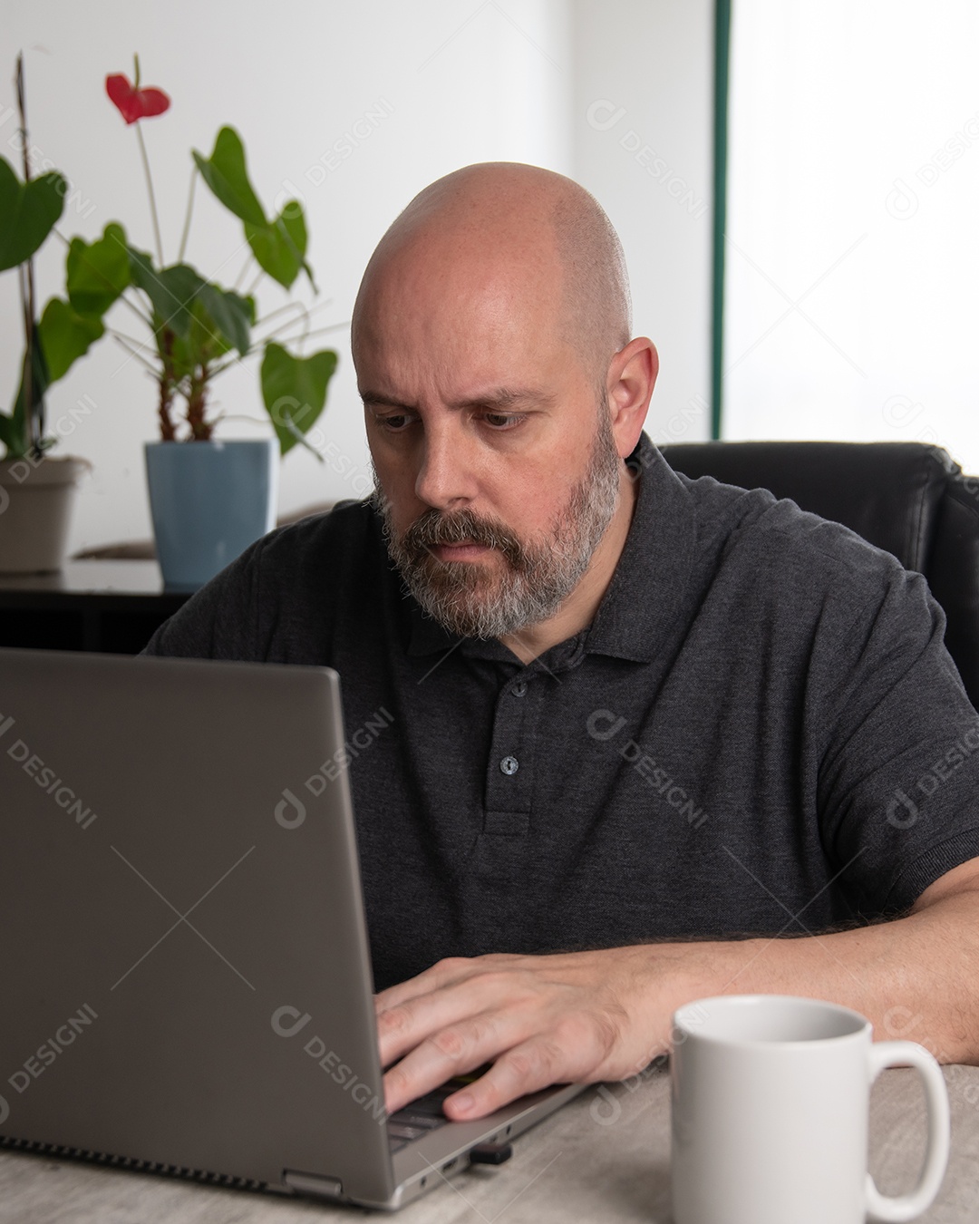 Homem de meia-idade brasileiro usando um laptop trabalhando em casa