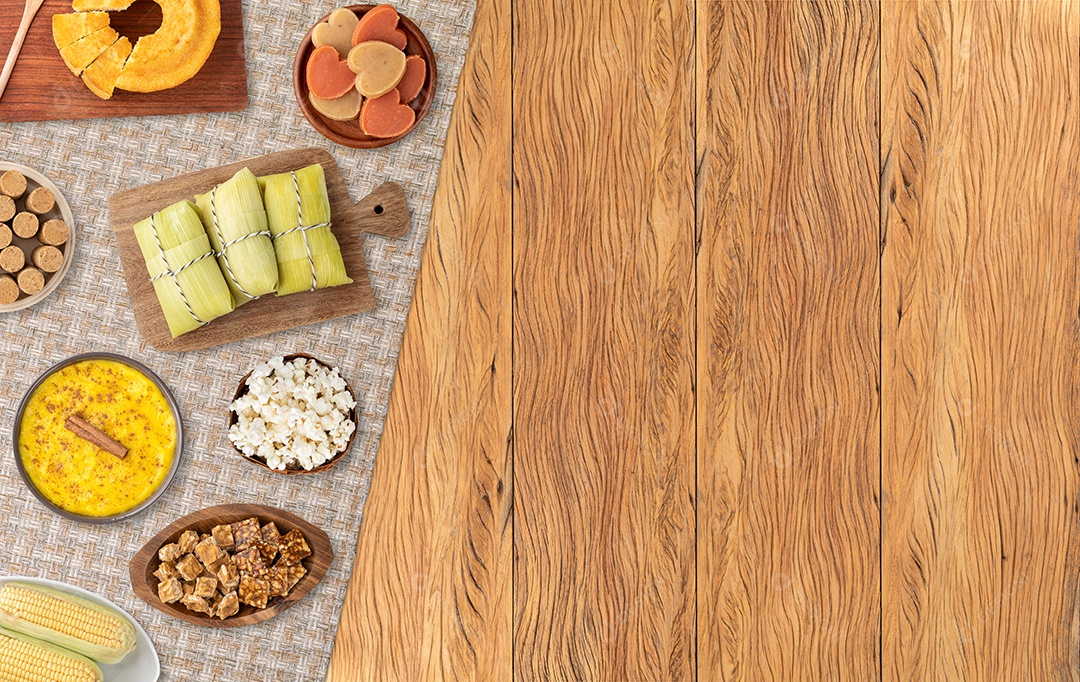 Comida típica do festival de junho brasileiro sobre mesa de madeira com cópia