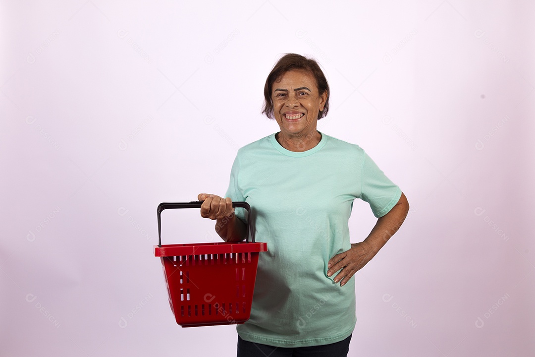 Mulher idosa segurando cesta de supermercado sobre fundo isolado