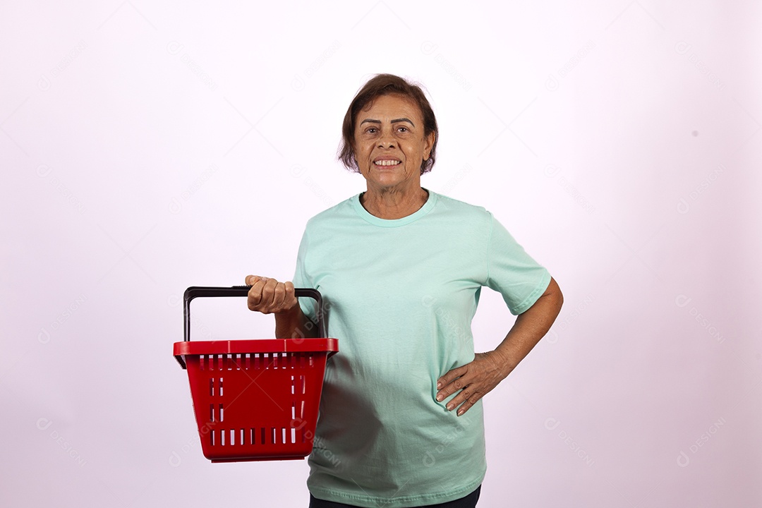 Mulher idosa morena segurando cesta de supermercado sobre fundo isolado