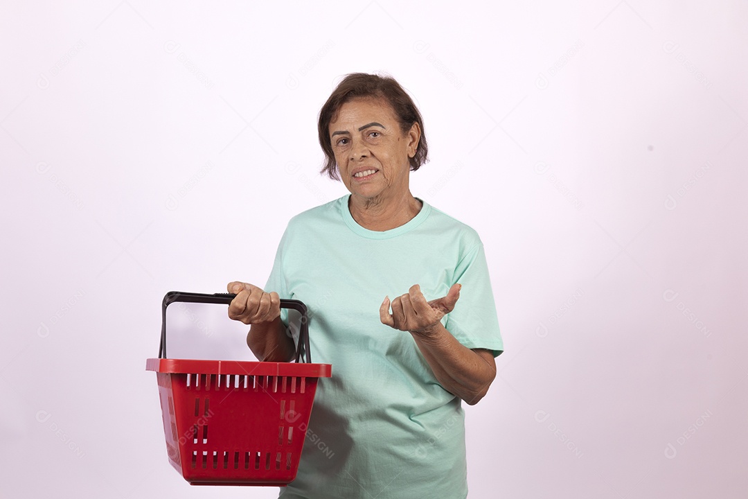 Mulher idosa morena segurando cesta de supermercado sobre fundo isolado