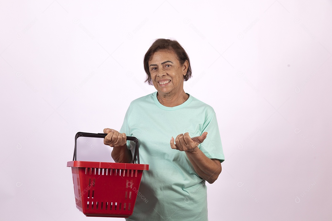 Mulher idosa morena segurando cesta de supermercado sobre fundo isolado