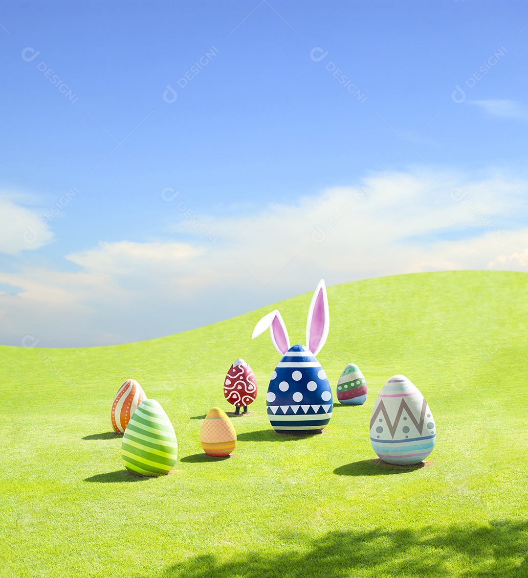 Ovos de Páscoa com orelhas de coelho na montanha de grama verde e fundo do céu azul
