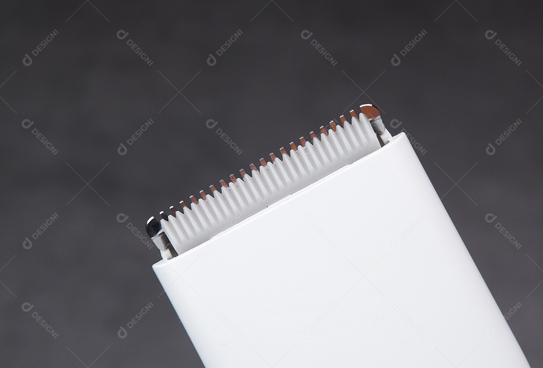 Lâmina de corte de cerâmica de uma máquina de cortar cabelo branca, objeto isolado em fundo escuro.