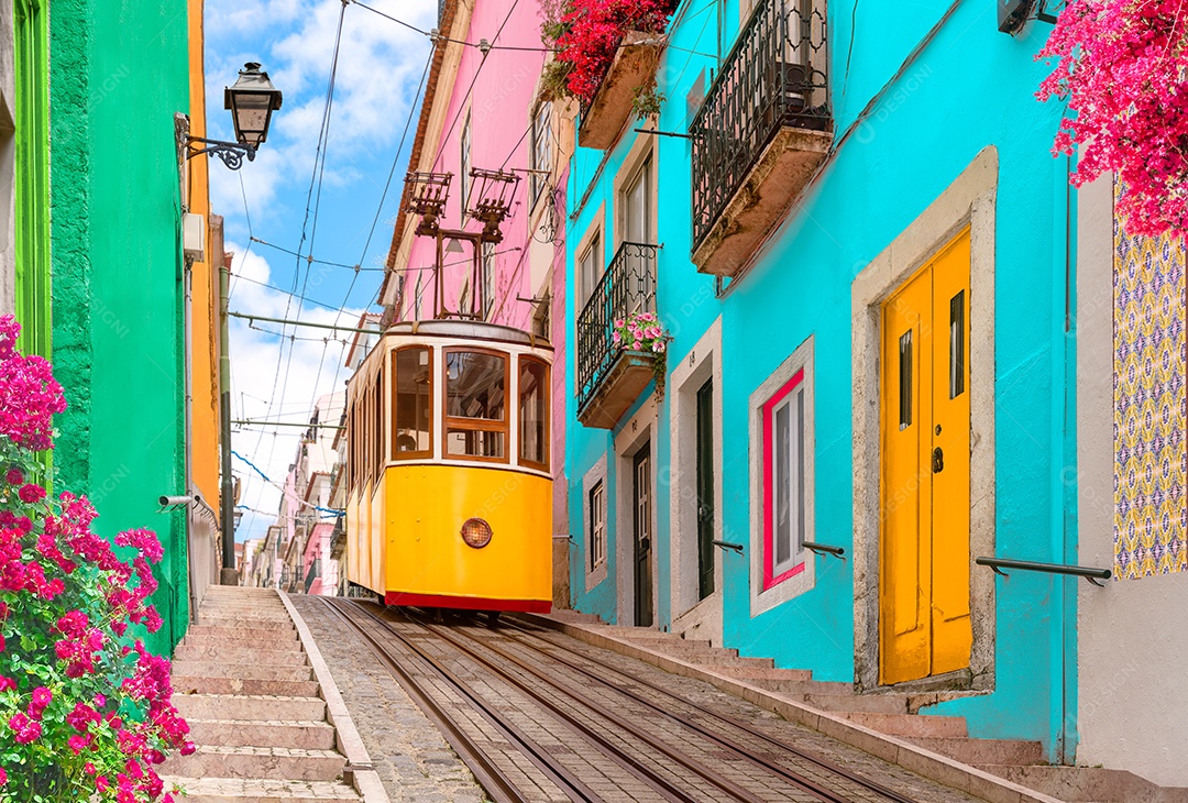 Eléctrico amarelo numa rua com casas coloridas e flores nas varandas - Elevador da Bica descendo a colina do Chiado em Lisboa, Portugal.
