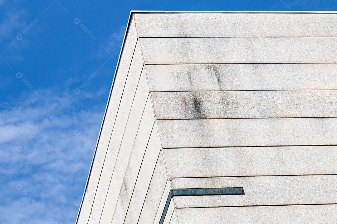 Detalhe superior do edifício branco mostrando detalhes arquitetônicos.