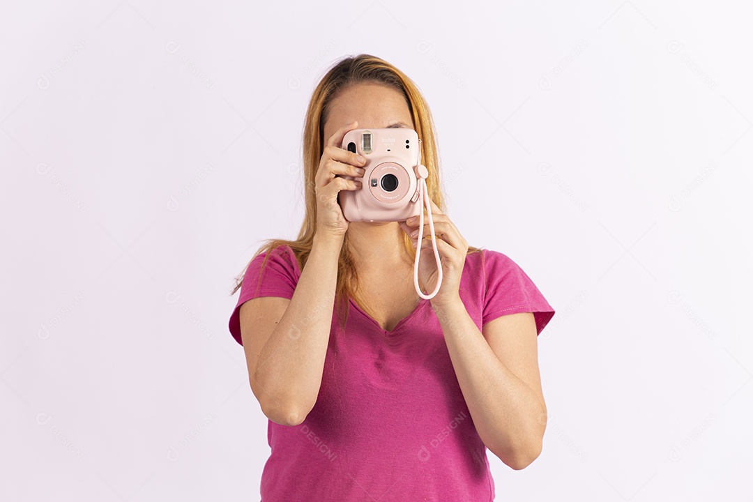 Linda mulher jovem segurando câmera fotográfica sobre fundo isolado