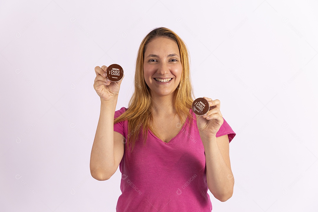 Mulher jovem segurando xícara e capsula de café