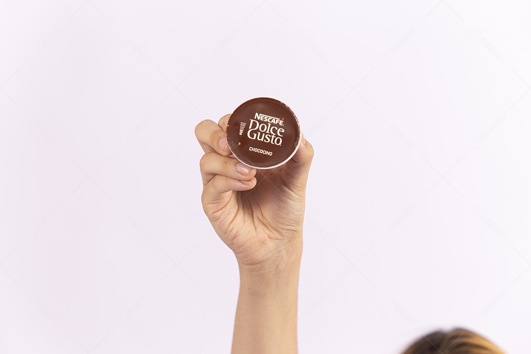 Mãos de pessoa segurando capsula de café