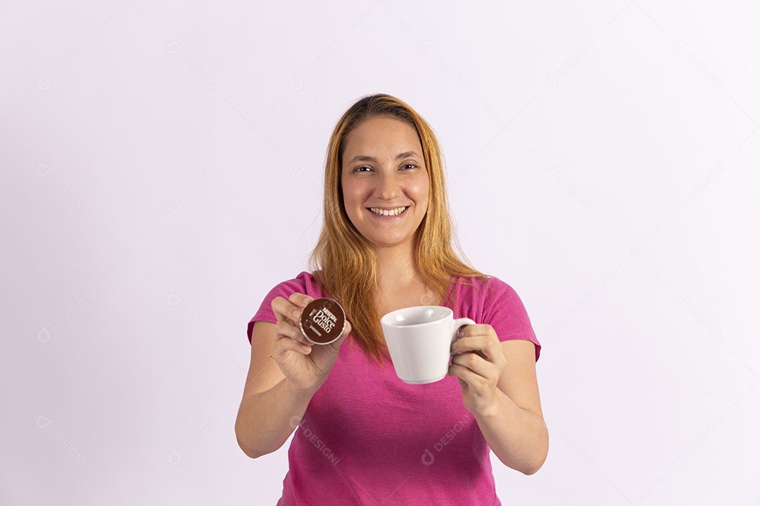 Mulher jovem segurando xícara e capsula de café