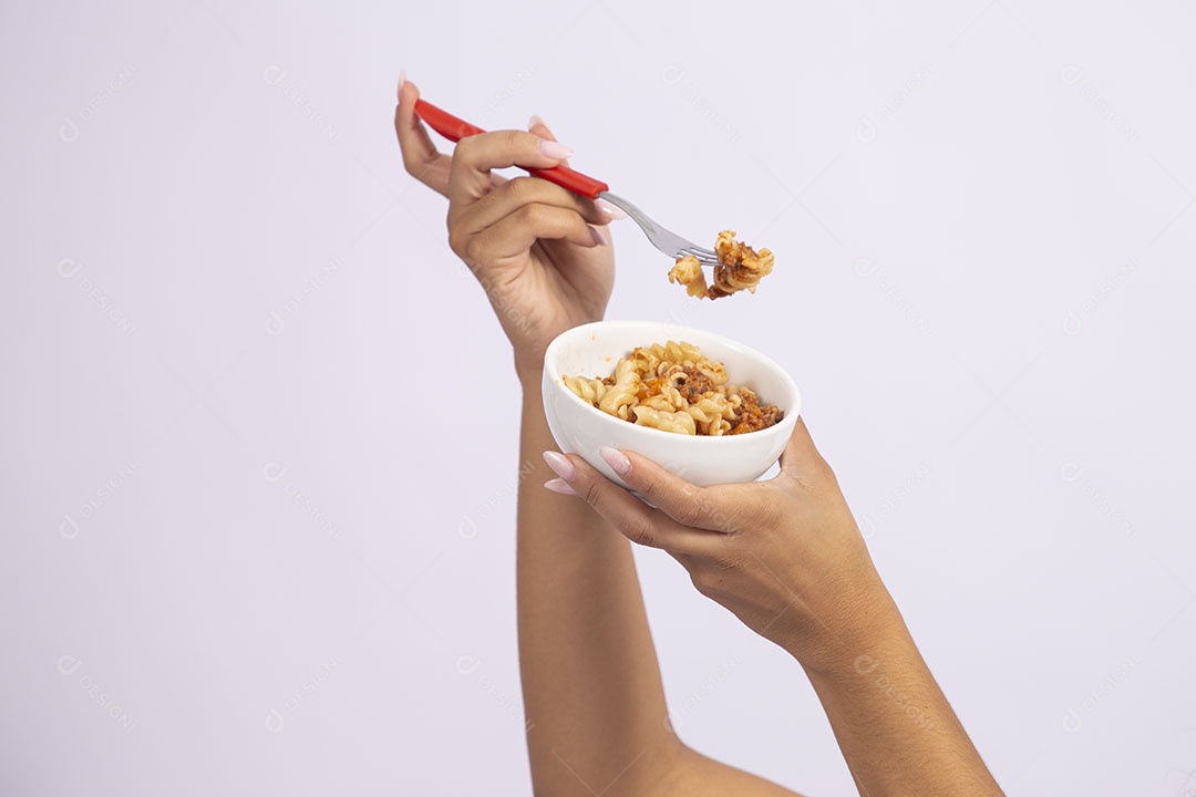 Mãos de pessoa segurando tigela de macarrão