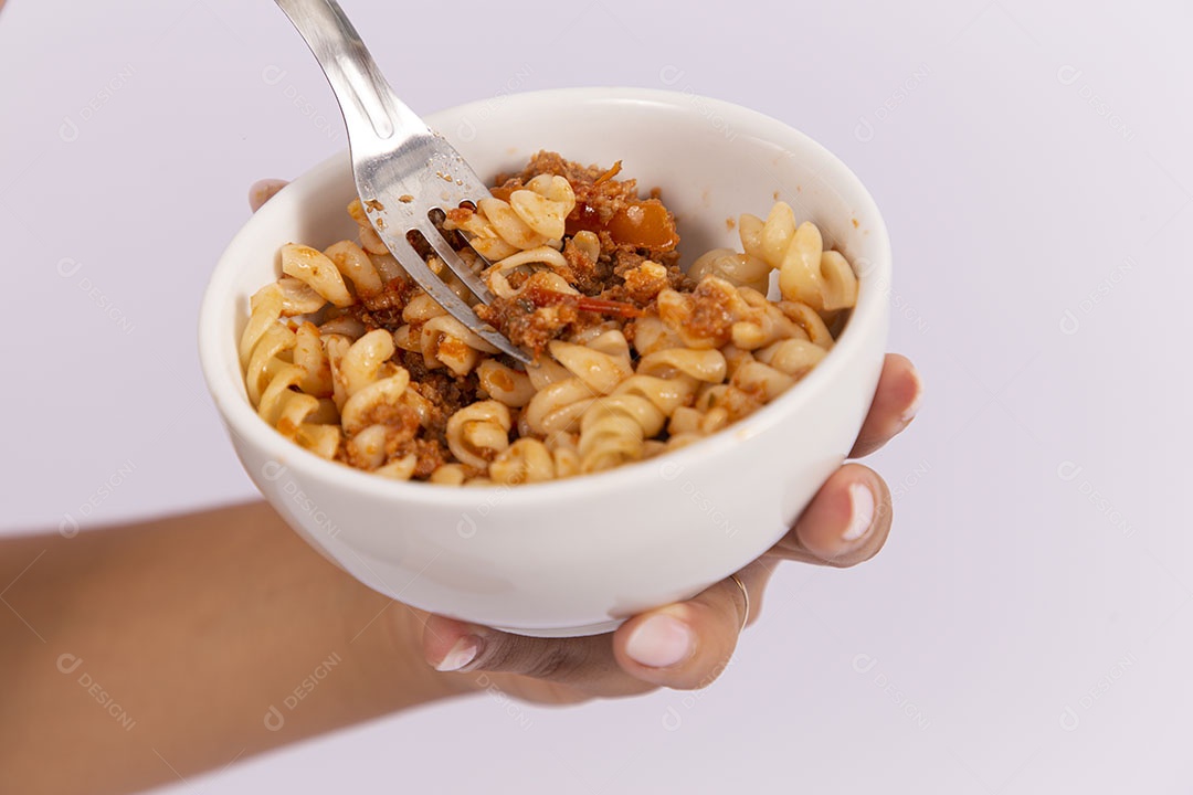 Mãos de pessoa segurando tigela de macarrão