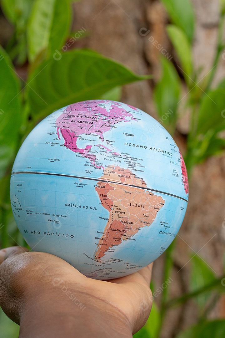 Mão segurando um globo terrestre com fundo de textura de madeira