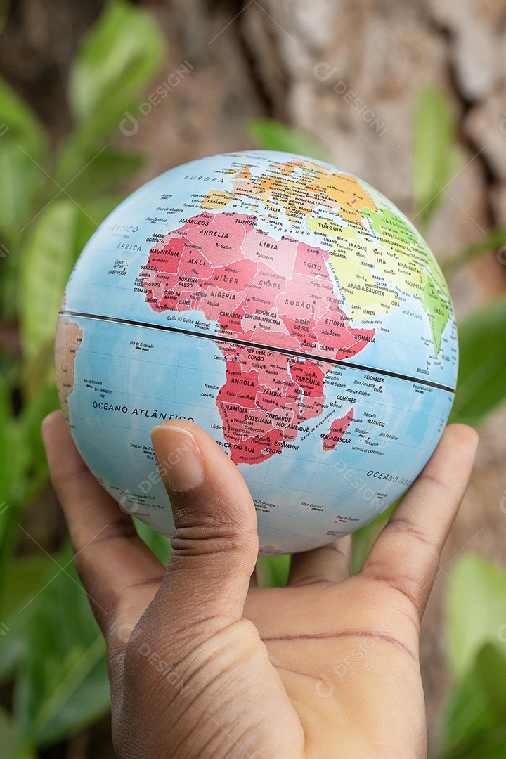 Mão segurando um globo terrestre com fundo de textura de madeira