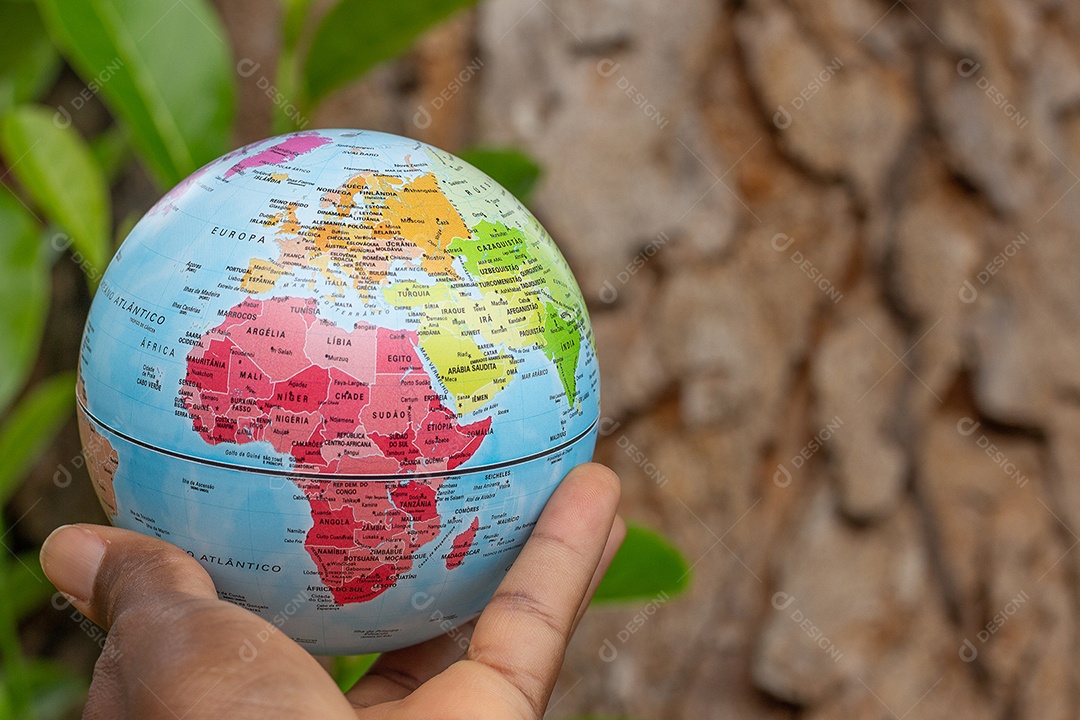 Mão segurando um globo terrestre com fundo de textura de madeira