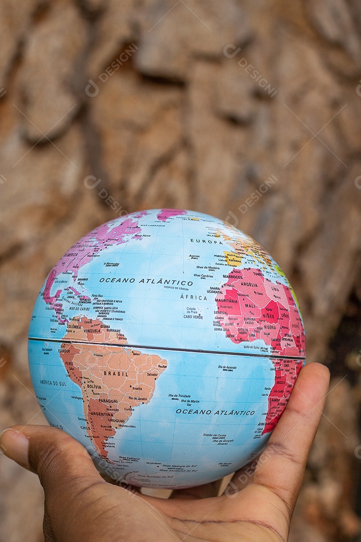 Mão segurando um globo terrestre com fundo de textura