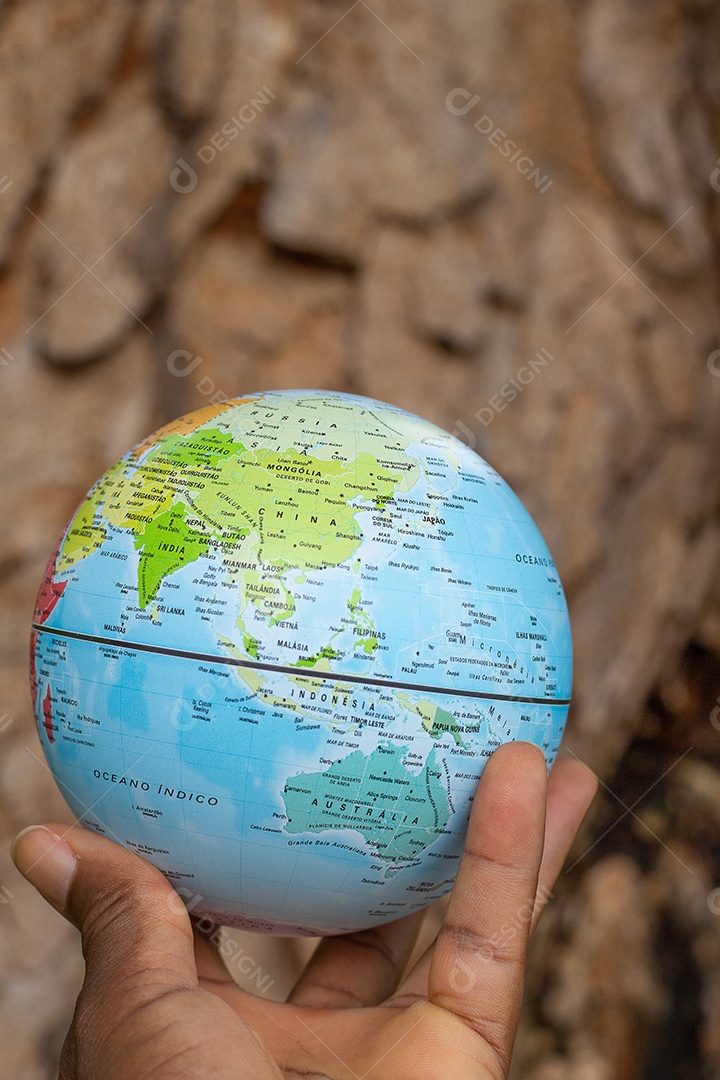 Mão segurando um globo terrestre com fundo de textura