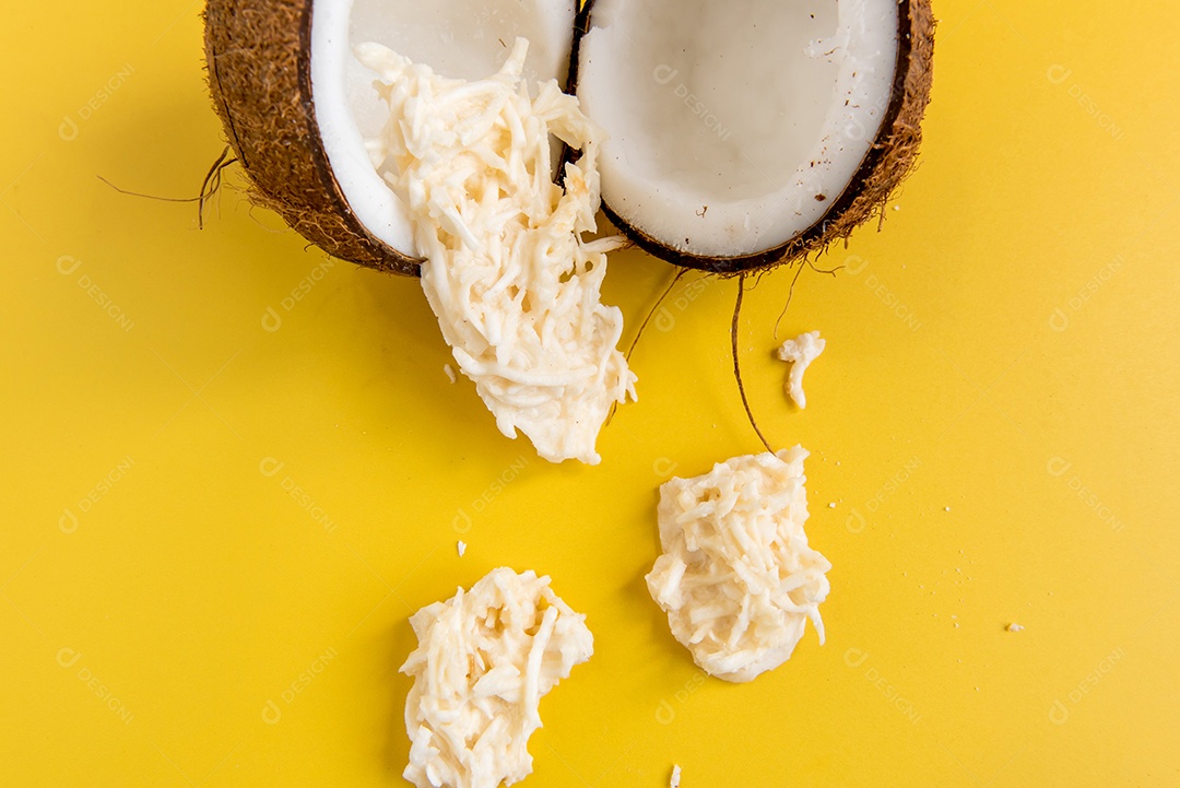 Coco e doce de coco (cocada) em fundo amarelo