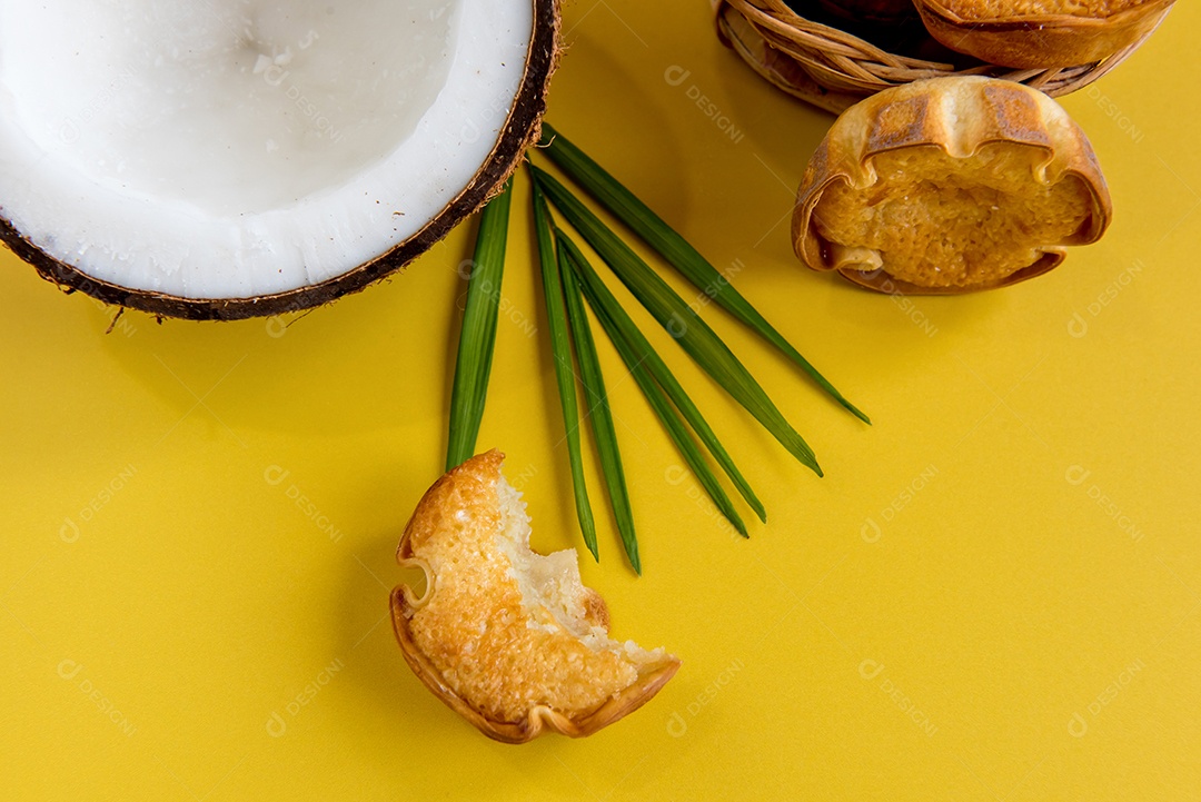 Coco e doce de coco (cocadinha) em fundo amarelo