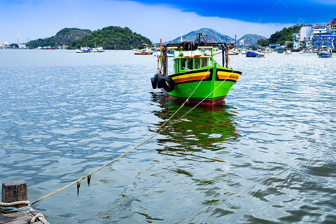 Barco verde amarrado ao cais em primeiro plano
