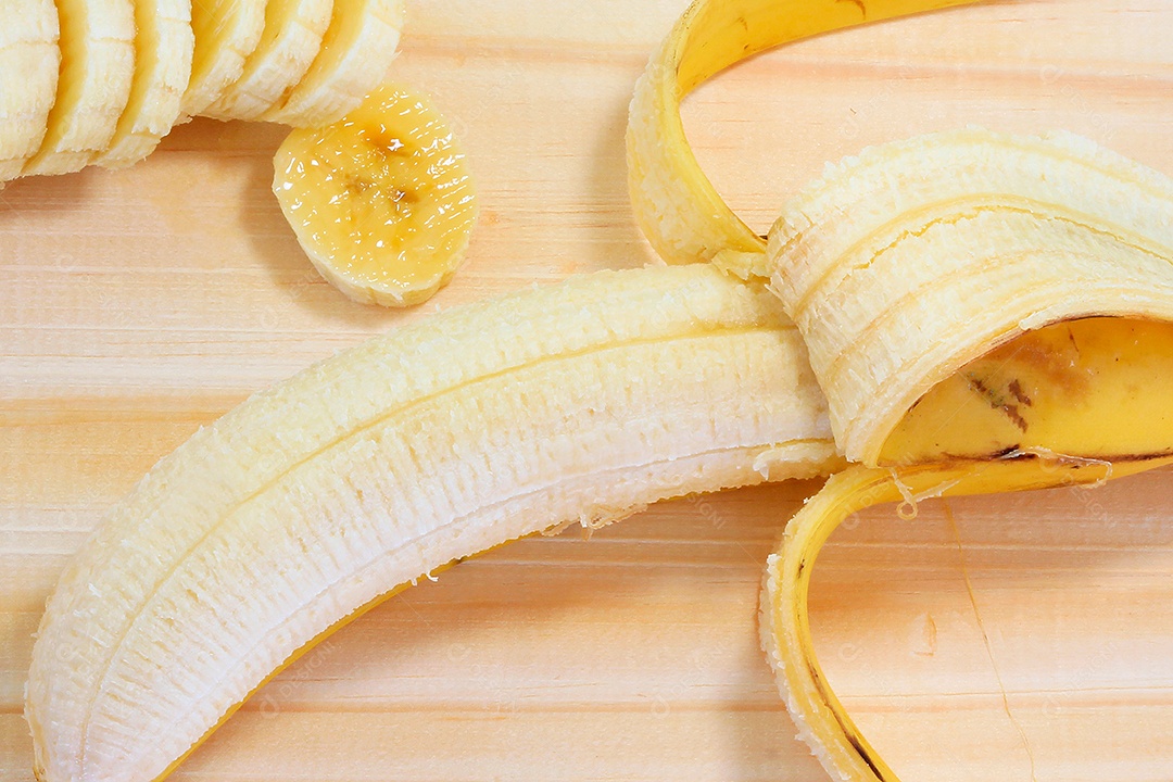 Fatias de banana na tábua de madeira. Lanche natural saudável.