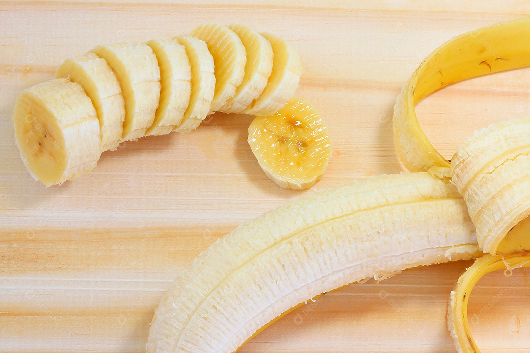 Fatias de banana na tábua de madeira. Lanche natural saudável.
