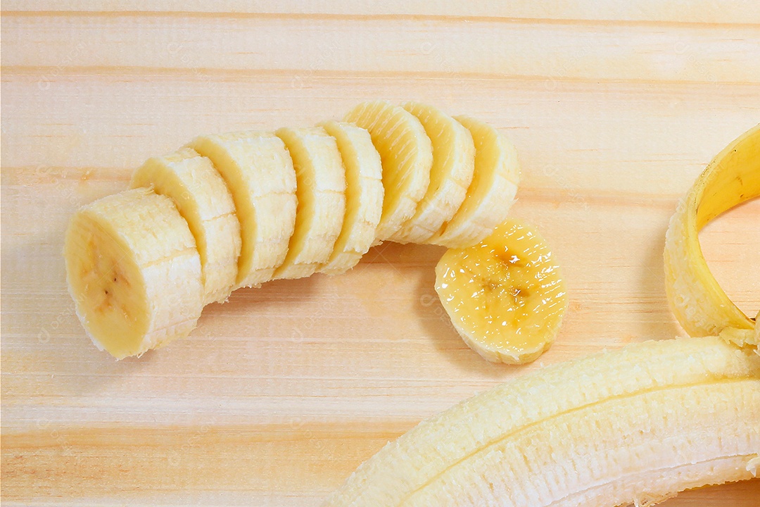 Fatias de banana na tábua de madeira. Lanche natural saudável.