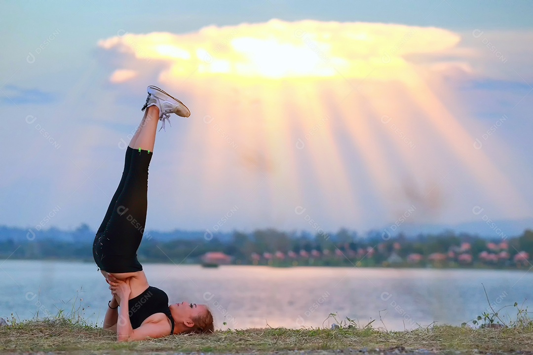 Jovem fazendo exercícios de fitness de ioga Nascer do sol ao ar livre na paisagem de belas montanhas do prado. Meditação e Relax.