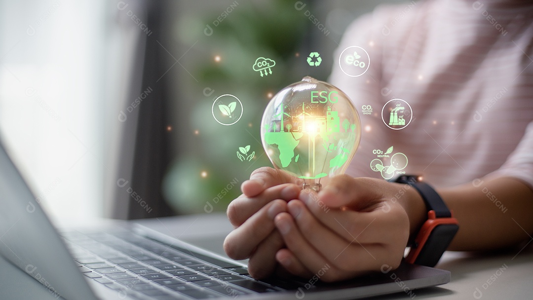 Mão de empresária segurando lâmpada com ícone ESG