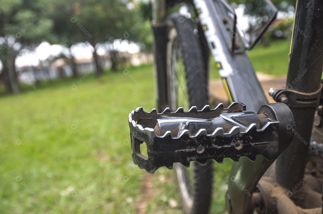 Banda de uma bicicleta em primeiro plano e bicicleta borrada à frente em uma praça, conceito de ciclismo.