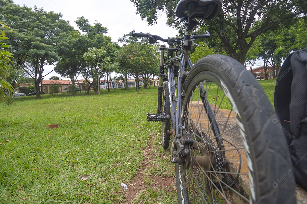 Banda de uma bicicleta em primeiro plano e bicicleta borrada à frente em uma praça, conceito de ciclismo.