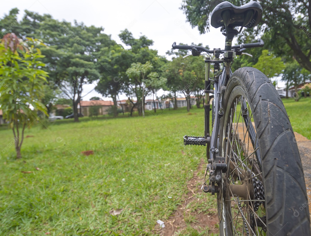 Banda de uma bicicleta em primeiro plano e bicicleta borrada à frente em uma praça, conceito de ciclismo.