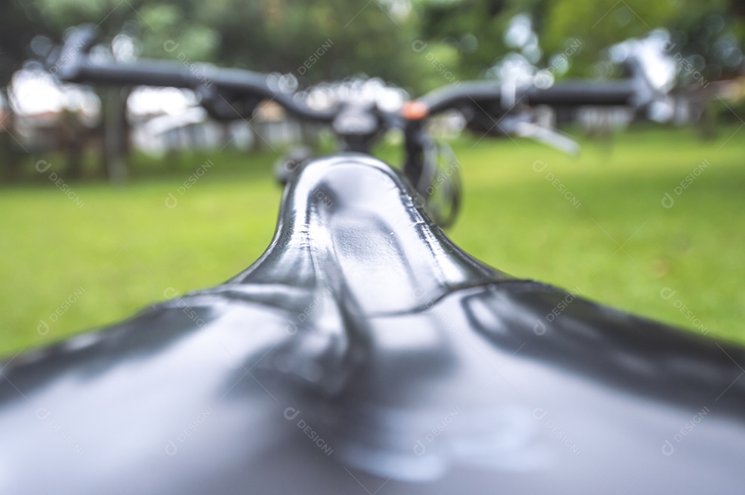 Banda de uma bicicleta em primeiro plano e bicicleta borrada à frente em uma praça, conceito de ciclismo.