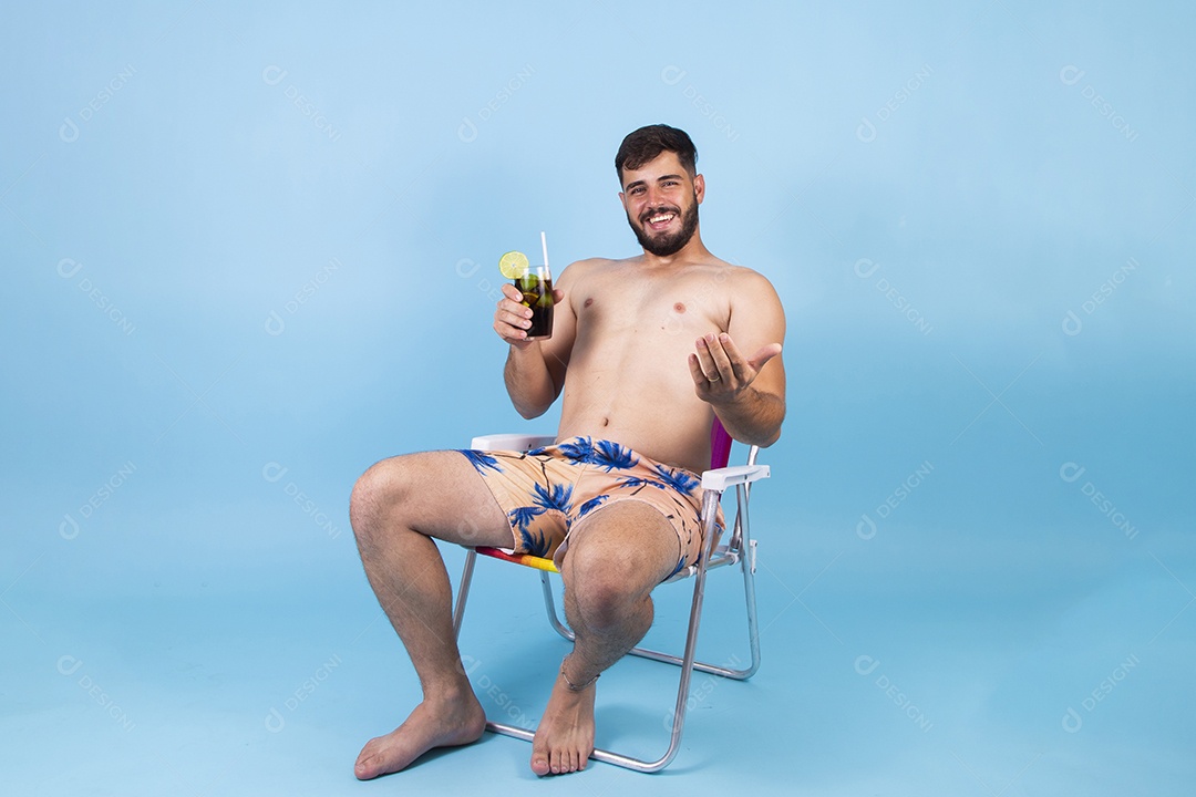 Homem jovem segurando bebida curtindo férias sobre fundo isolado