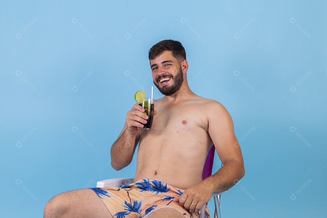 Homem jovem segurando bebida curtindo férias sobre fundo isolado