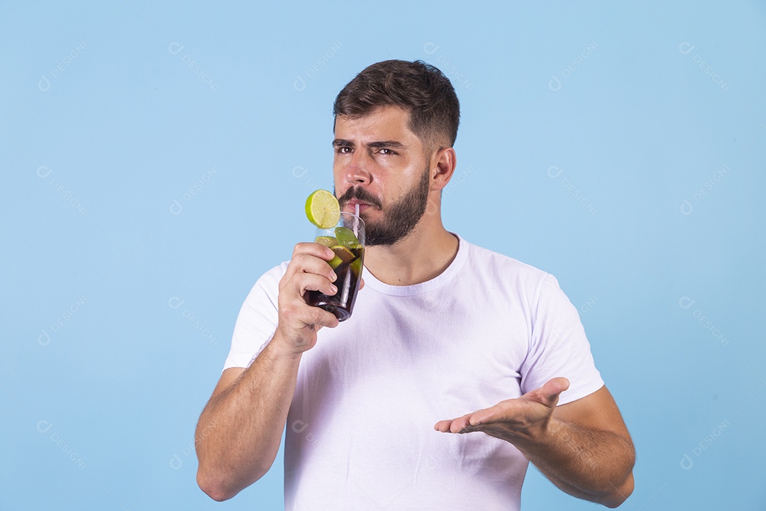 Homem jovem segurando bebida curtindo férias sobre fundo isolado