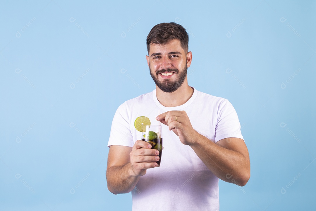 Homem jovem segurando bebida curtindo férias sobre fundo isolado