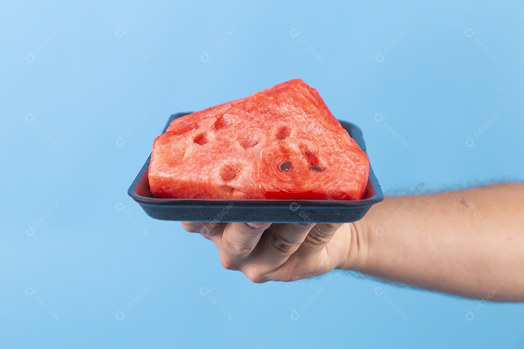 Mãos de jovem segurando prato de melancia sobre fundo isolado