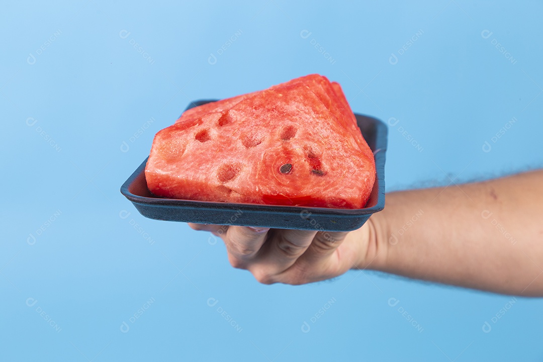 Mãos de jovem segurando prato de melancia sobre fundo isolado