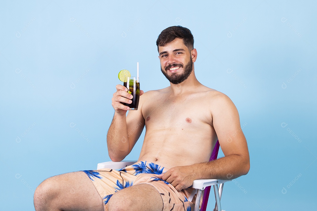 Homem jovem segurando bebida curtindo férias sobre fundo isolado